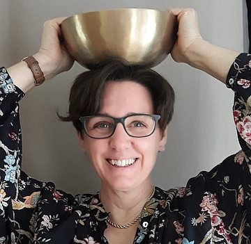 Heike Euler mit einer Klangschale auf dem Kopf